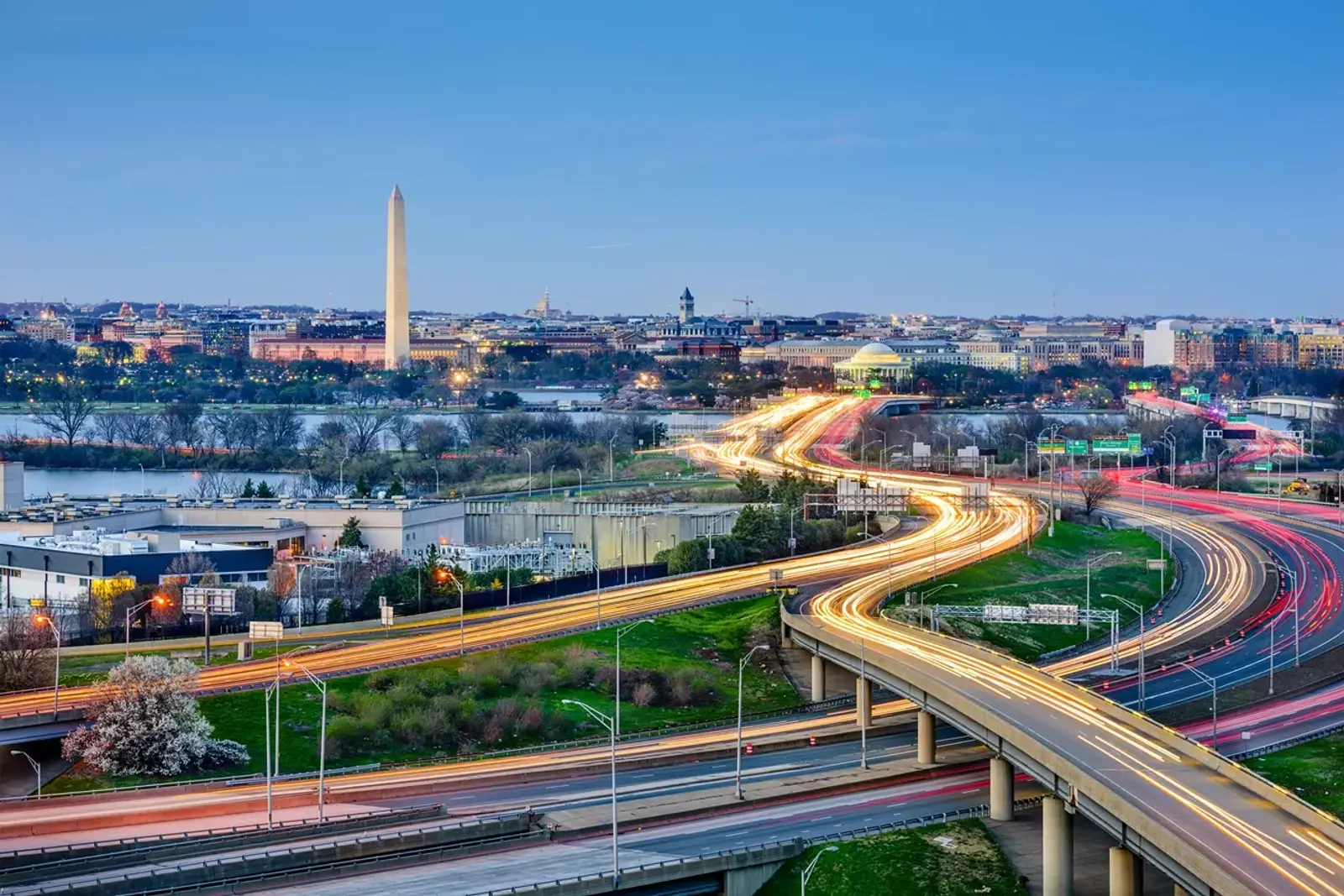 Washington at dusk: the Monument, the river, and the parkways lit by headlights.